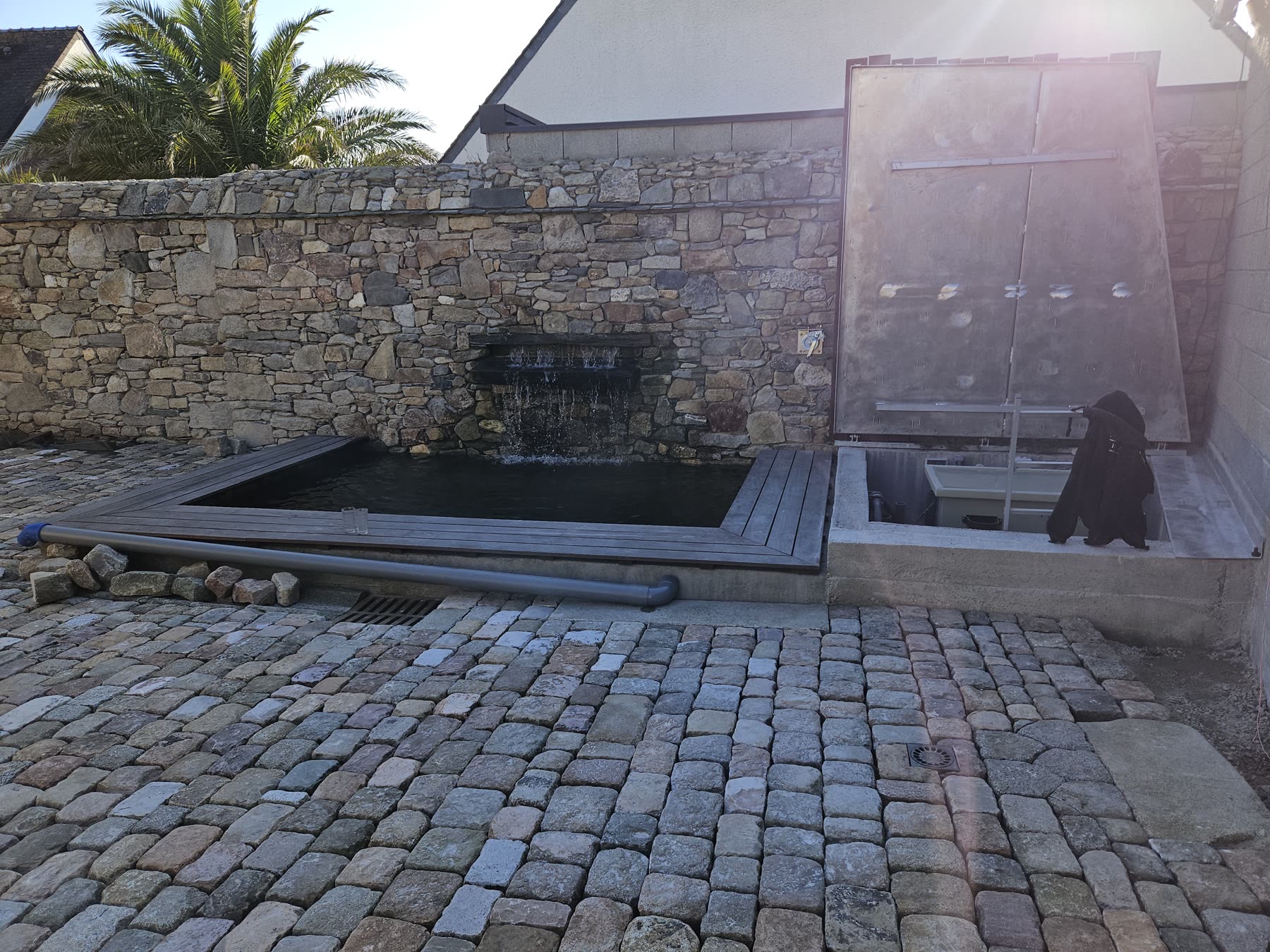 Lame d’eau dans un mur de pierre, patio pavé clos de murs — Roscoff